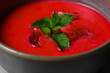 Cold beetroot soup with mint in a bowl on a gray background