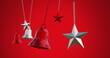 Image of multiple bells and stars hanging and swinging against red background