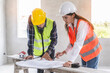 © Pormezz - Concept Teamwork of building construction staff. Project engineer contractor reviewing plan of work with foreman and worker at construction site.