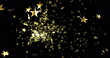 Image of stars falling over golden star on black background