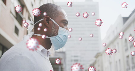 Canvas Print - Image of covid 19 cells over african american man wearing face mask