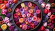   A bowl brimming with an array of multi-colored blooms atop a gray counter, adorned with a profusion of pink, orange, and purple blossoms