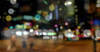 Image of road traffic in city at night with blurred city lights and colourful spots of light in the 