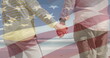 Image of senior caucasian couple holding hands on beach over flag of united states of america