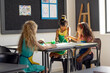 In school, in art class, a diverse group of young girls painting together