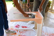 Biracial mother and adult daughter are painting a table together at home as an upcycling project