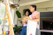 Biracial mother and adult daughter are painting together at home
