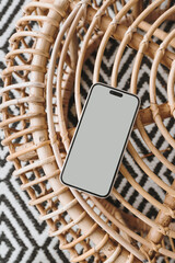 Wall Mural - Flatlay mobile phone on ornamental bamboo table and carpet. Aesthetic elegant blog, online shopping, online store, social media branding mock up with blank copy space