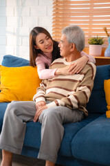 Wall Mural - Capture the Joy of Family: Happy Grandparents Enjoying Retirement Indoors, Hugging Their Children and Grandchildren on a Couch, Sharing Smiles and Togetherness Across Generations