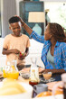 © Wavebreak Media - Woman patting boy's head, both holding strawberries, sitting at breakfast table at home