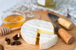 Soft cheese with white mold Camembert, honey, nuts and a bottle of wine in the background. Close-up. Selective focus.