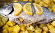 Baked fish Dorado with potatoes in the oven. Close-up. Selective focus.