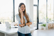 © InsideCreativeHouse - Cheerful young businesswoman talking by the cellphone with customers dealing with work issues at home. Freelance and remote job, multitasking and solving working issues