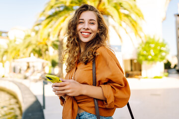 Young caucasian woman smiling happy using smartphone at the city.  Technology, blogging, travel, shopping, communication concept