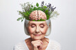 senior woman with herbs and brain on her head with healthy thoughts on a white background