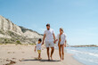 © blackday - Happy family enjoys a playful walk along the sea on a Mediterranean beach