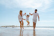 © blackday - Happy family enjoys a playful walk along the sea on a Mediterranean beach
