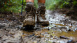 A backpackers boots covered in mud at the end of a long days trek standing on a rugged trail showcasing the gritty reality and the physical demands of backpacking adventures.