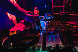 Fototapeta Las - DJ hand on mixing equipment