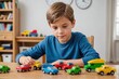 Boy sitting at a table playing with toy vehicles