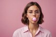 Portrait of cool young woman with bubble gum in front of pink background,studio shot