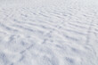 Landscape of fresh and clean snow on the ground in the winter on a sunny day, viewed from above. Abstract full frame textured background. Good as a natural winter season background with copy space.