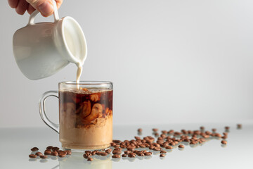 Wall Mural - Pouring milk in black coffee.