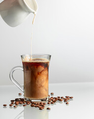 Wall Mural - Coffee with cream on a glass table.