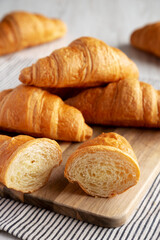 Wall Mural - Homemade Breakfast Croissants on a Wooden Board, side view.