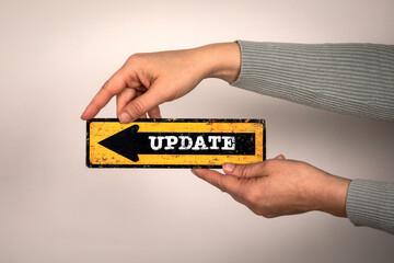 Wall Mural - update concept. pointing arrow with text in hands on white background