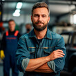 An auto body repair technician confidently stands in a workshop, arms crossed.