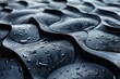 Dark, glossy curved surfaces with fresh water droplets, evoking a sense of fluidity and organic movement
