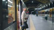 Woman leaving train wagon looking smartphone. Short hair businesswoman arrive