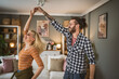 © Miljan Živković - One adult couple dance together and have fun at living room at home
