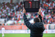 Technical referee shows added time during football match.