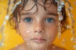 Macro shot of a young child's face covered with water droplets highlighting blue eyes