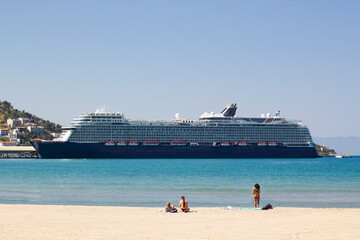 Wall Mural - View from the beach of a very large tourist cruise ship tied up in the port