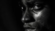 In this monochrome portrait a proud Black mans face is illuminated by a single ray of light emphasizing the deep coffee hues and warm undertones in his skin. The simplicity of the .