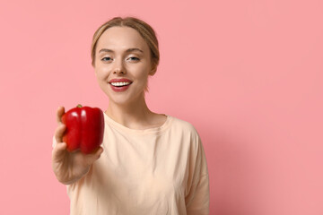 Wall Mural - Young woman with bell pepper on pink background, closeup