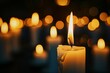 Lit candle on a dark background with bokeh