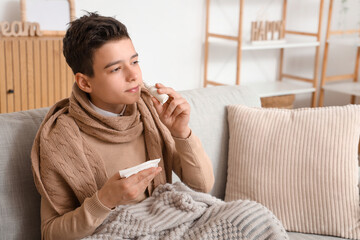 Wall Mural - Sick little boy using nasal drops at home