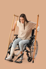 Poster - Injured young woman after accident with crutches standing up from wheelchair on brown background