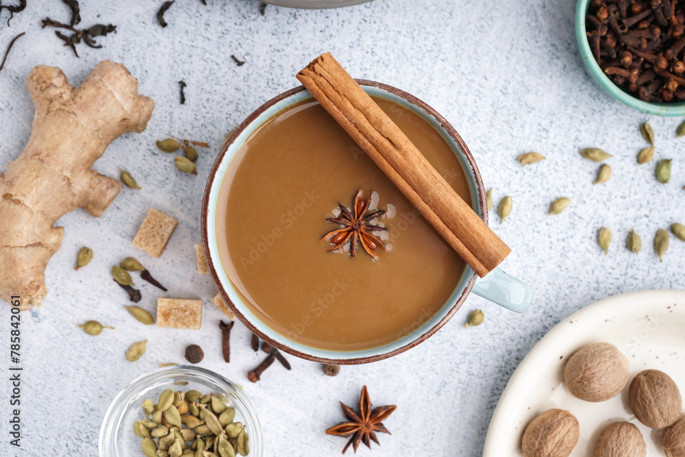 Cup of delicious masala tea with different spices on light background, closeup