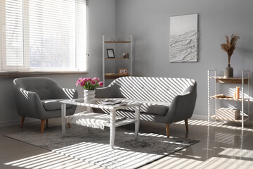 Wall Mural - Interior of light living room with sofa, armchair and tulips on table