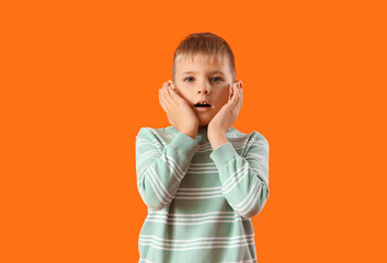 Wall Mural - Shocked little boy on orange background