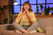 © Pixel-Shot - Young woman sitting and relaxing on sofa in living room