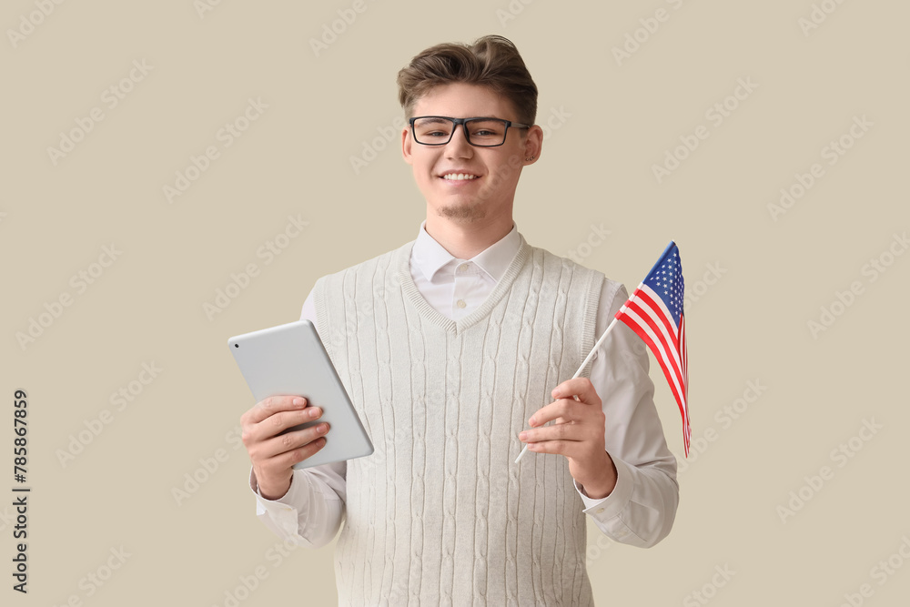 Male teacher with USA flag and tablet computer on beige background
