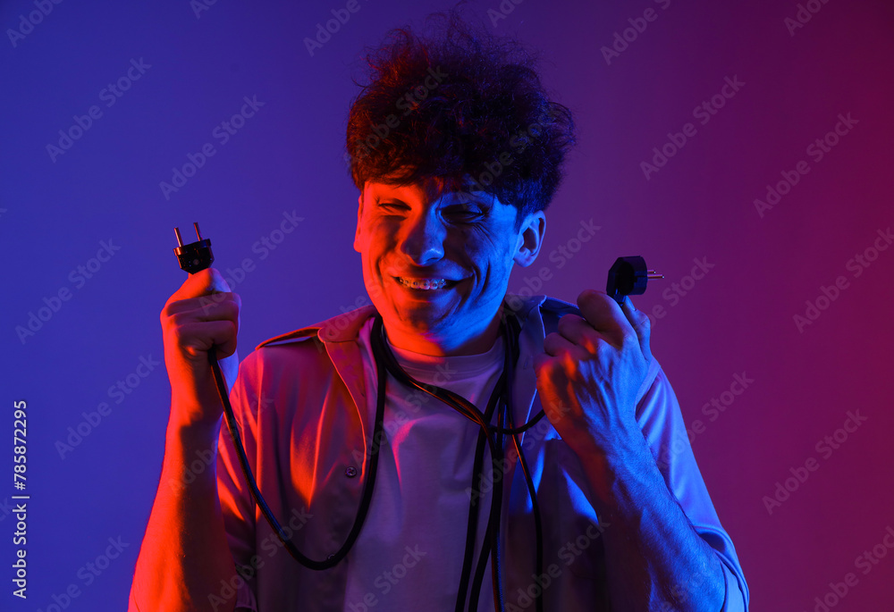Electrocuted young man with burnt face and plugs on dark background, closeup