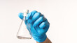 Hand in blue glove holding empty tube for laboratory research. Empty laboratory test tube in doctor's hand on white background close-up. Concept medicine, biological research and chemical experiments