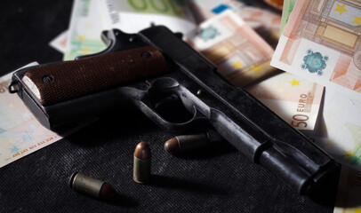 close up of colt 1911, ammos and money, suitcase on background